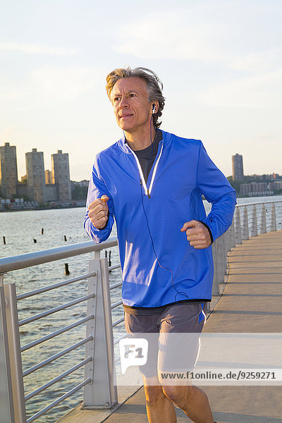 Caucasian man jogging on urban waterfront