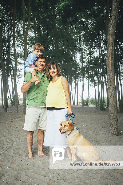Family smiling together on wooded beach