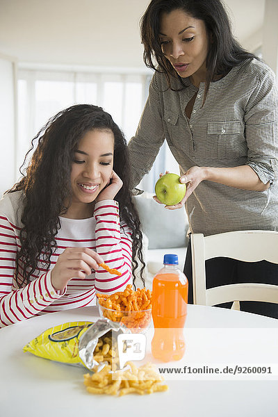Mother offering daughter healthy snack