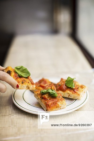 Small slices of pizza topped with basil