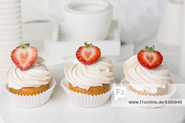 Drei Erdbeer-Cupcakes mit Buttercreme