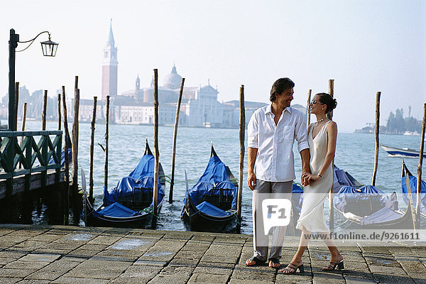 Couple holding hands on urban canal front  Venice  Veneto  Italy