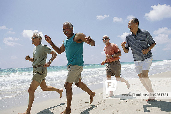 Senior couples jogging on beach