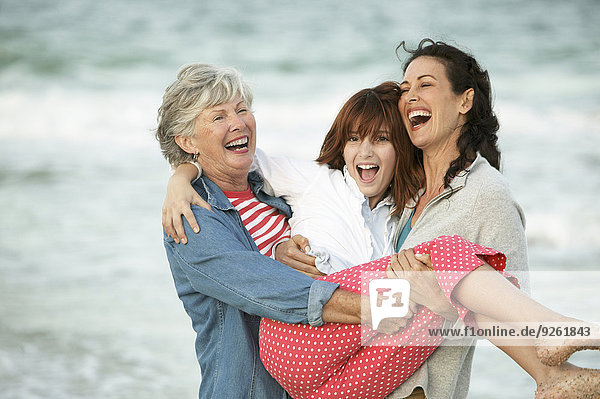Three generations of women playing on beach