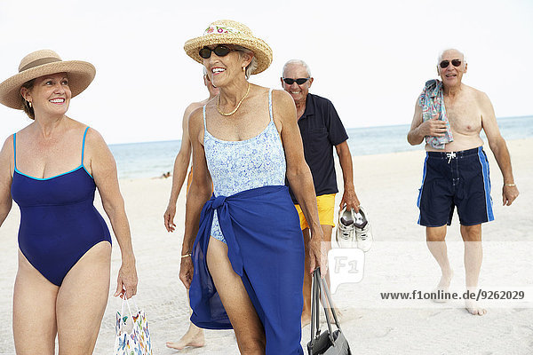 Senior friends walking on beach