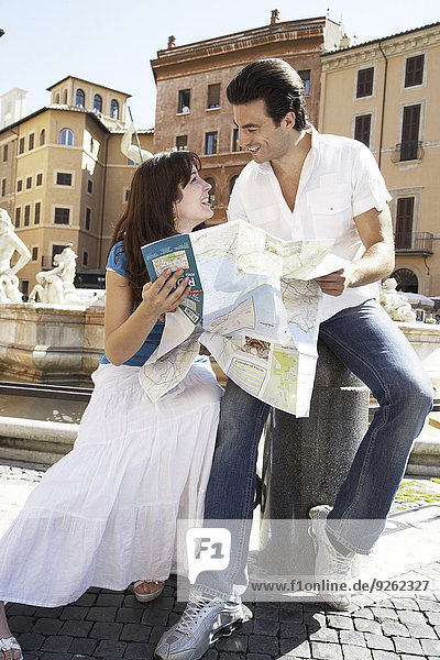 Caucasian couple reading map at Piazza Novona  Rome  Italy
