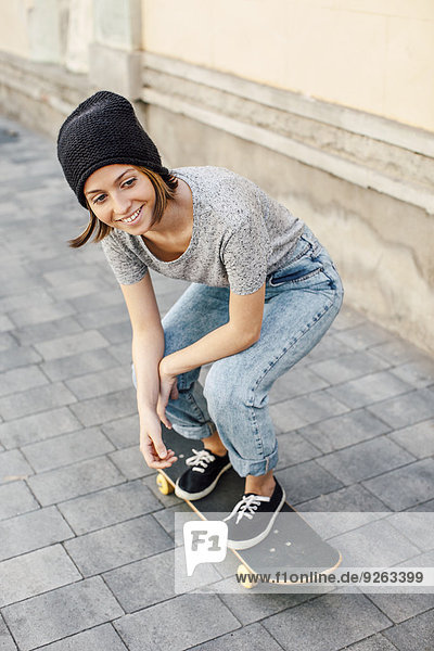 Porträt einer lächelnden jungen Skateboarderin
