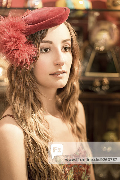 Portrait of young woman wearing red old hat