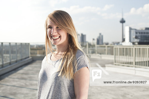 Deutschland  Nordrhein-Westfalen  Köln  Porträt einer lächelnden jungen Frau auf Parkebene