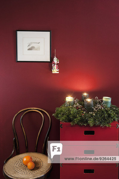 Advent wreath on sideboard at red wall