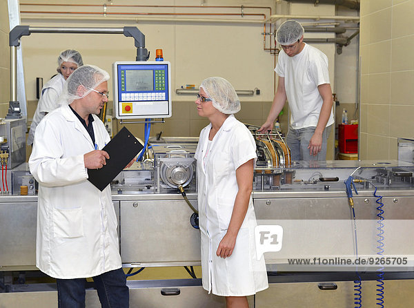Germany  Saxony-Anhalt  staff talking about workflow in a baking factory