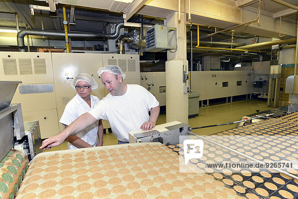 Deutschland  Sachsen-Anhalt  zwei Arbeiter an der Produktionslinie mit Keksen in einer Backfabrik