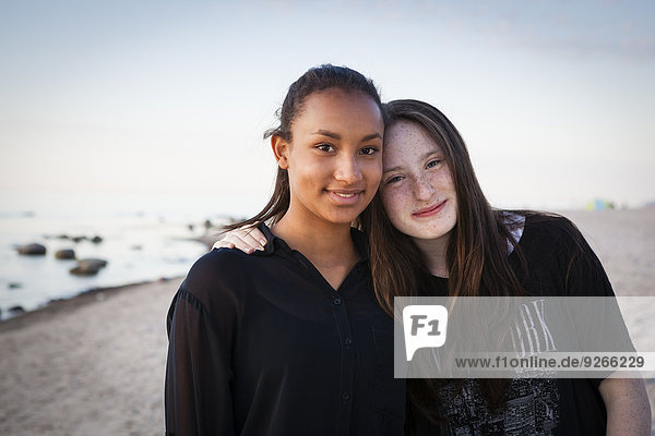 Germany  Ruegen  Two young female friends at the beach