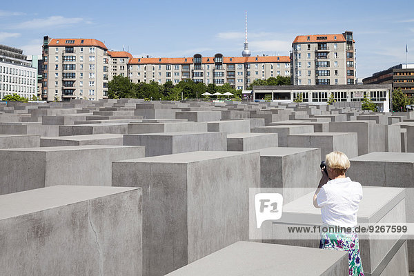 Deutschland,  Berlin,  Holocaust-Mahnmal,  Reife Frau fotografiert Stelen