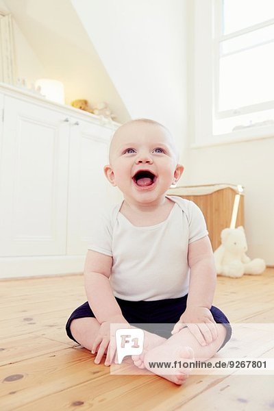 Portrait of smiling baby boy sitting on floor