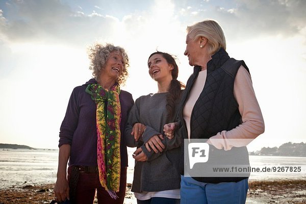 Weibliche Familienmitglieder beim Plaudern am Strand