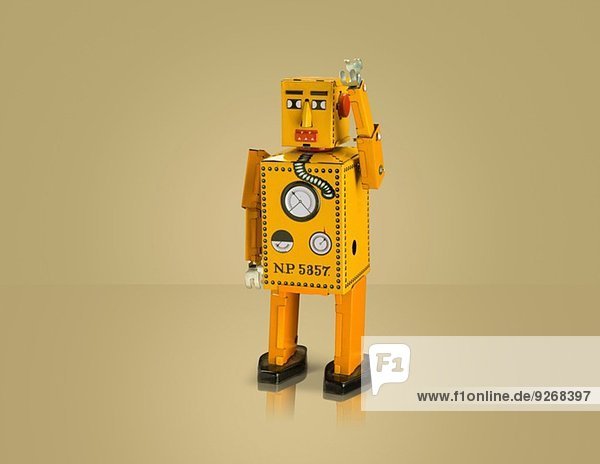 Studioaufnahme eines gelben Roboters mit angehobenem Arm