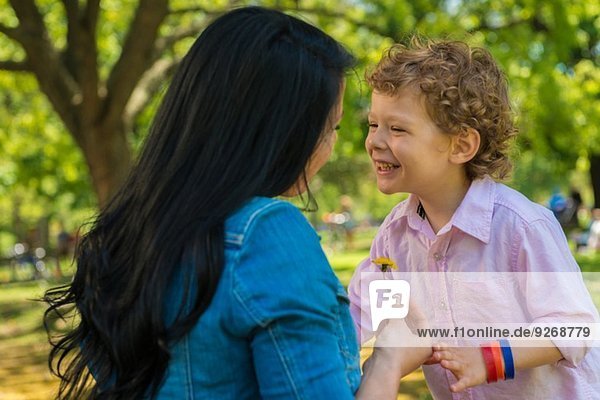 Junge Mutter und Sohn lachen zusammen im Park