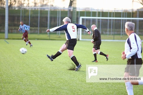 Fußballspieler der den Ball kickt