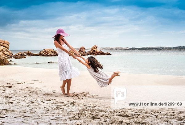 Junge Frau schwingende Tochter am Strand  La Maddalena  Sardinien  Italien
