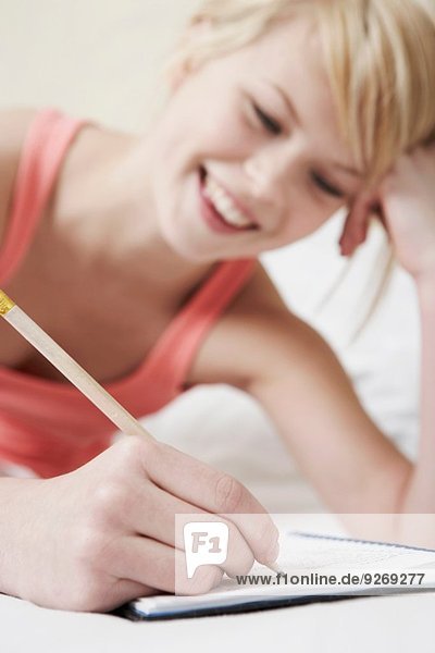 Teenage girl writing in notebook