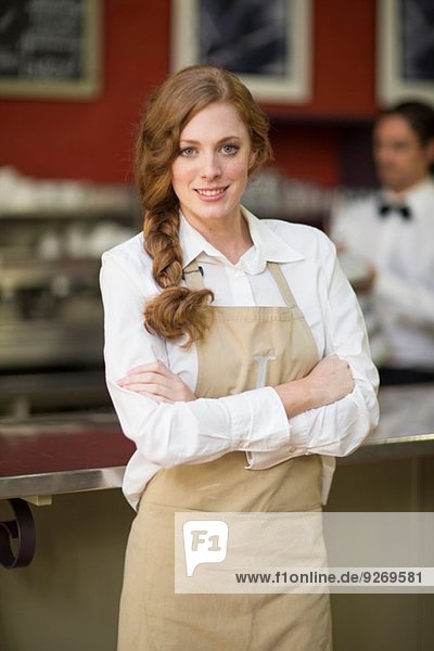 Porträt der Kellnerin mit gefalteten Armen im Restaurant