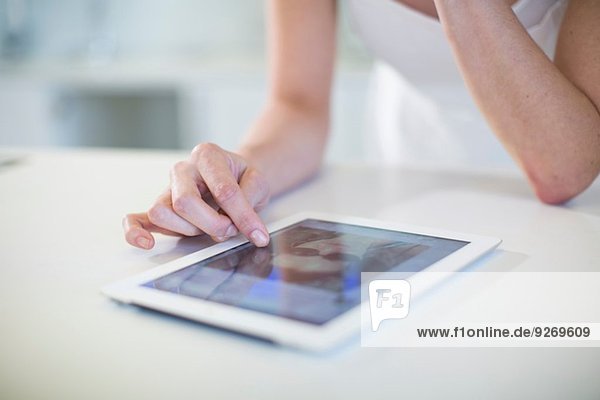Nahaufnahme der Hand junger Frauen mit digitalem Tablett-Touchscreen an der Küchenzeile