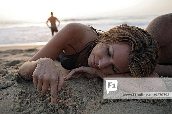 liegend liegen liegt liegendes liegender liegende daliegen junge Frau junge Frauen Strand Sand Ansicht spielen