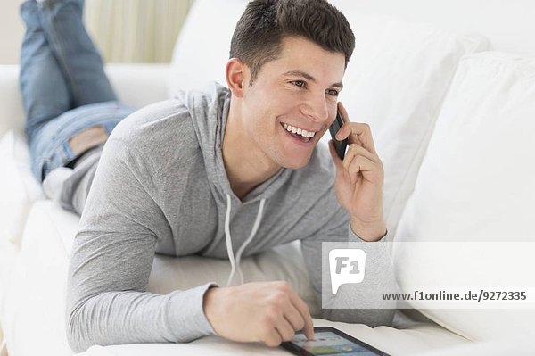 Young man using tablet and talking by phone