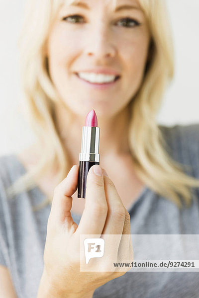 Portrait Frau Lippenstift halten pink Studioaufnahme blond