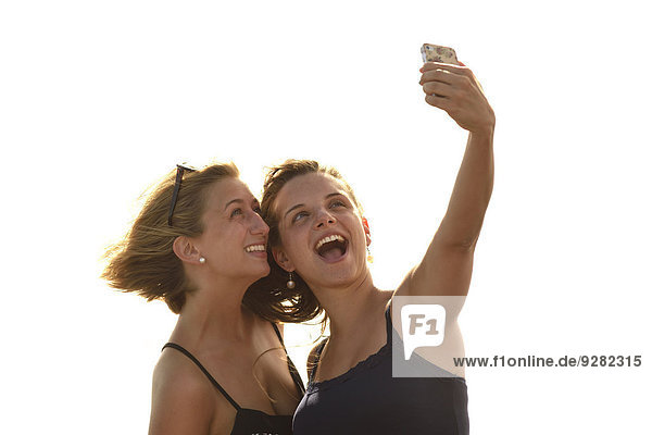 Selfie  two young women taking a self-portrait with a mobile phone  Lanzarote  Canary Islands  Spain