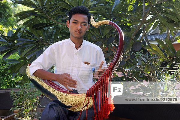 Burmese man playing the Saung Gauk  Burmese harp or arched harp  national instrument of Myanmar  Bagan  Mandalay Region  Myanmar