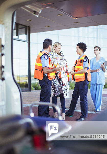 Sanitäter im Gespräch mit dem Patienten auf dem Krankenhausparkplatz