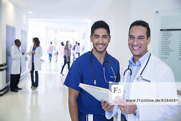 Arzt und Krankenschwester lächeln im Krankenhausflur
