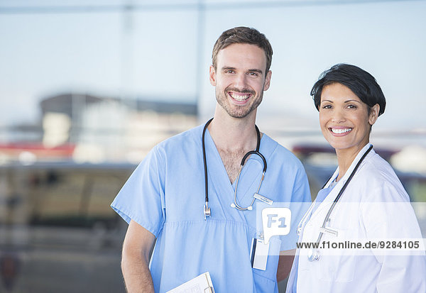 Arzt und Krankenschwester lächeln im Freien