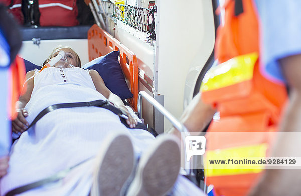 Rettungssanitäter bei der Untersuchung des Patienten auf der Trage im Krankenwagen