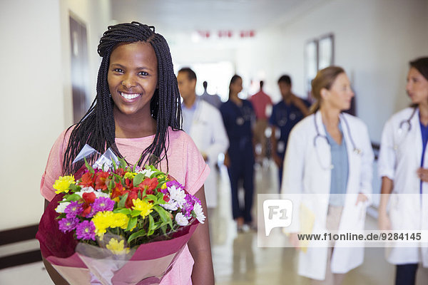 Patient holding bouquet of flowers in hospital