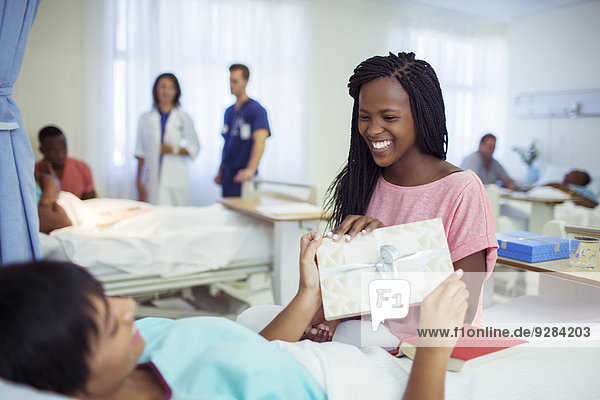 Frau gibt dem Freund eine Karte im Krankenhauszimmer