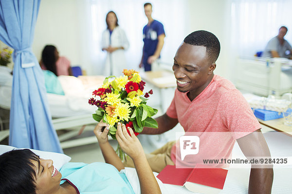 Mann schenkt Freundin Blumenstrauß im Krankenhaus