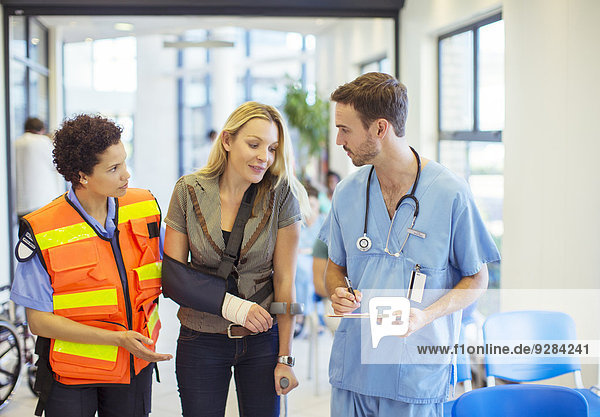 Krankenschwester und Sanitäter im Gespräch mit dem Patienten im Krankenhaus