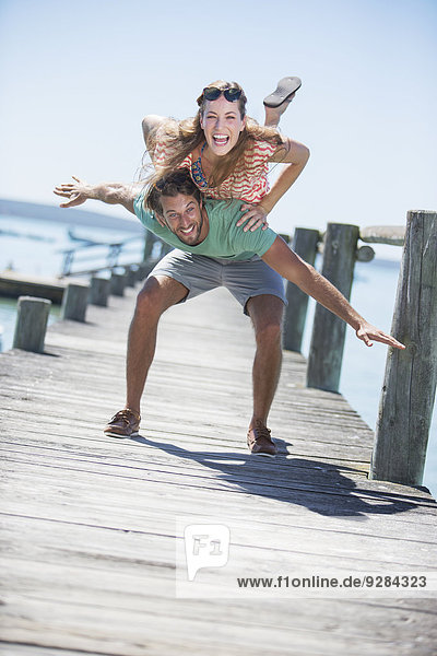Couple playing on wooden dock