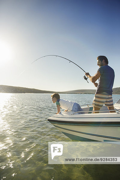 Vater und Sohn fischen auf dem Boot