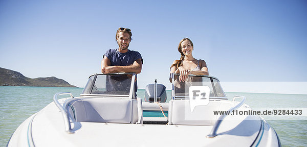 Couple standing in boat on water