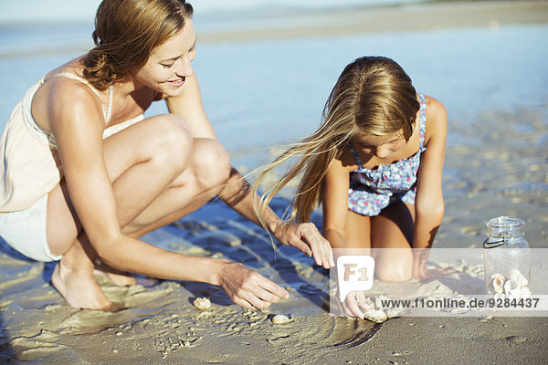 Mother and daughter playing in sand