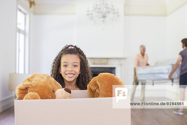 Junges Mädchen trägt Box mit Teddybär im Innern