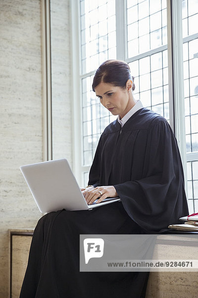 Richter auf der Bank sitzend mit Laptop im Gerichtsgebäude