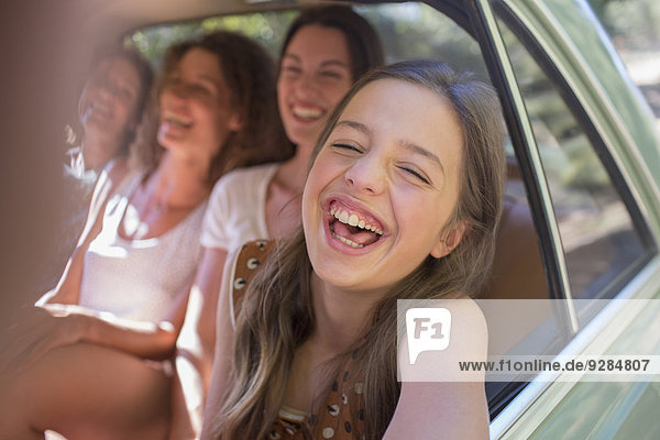 Vier Frauen spielen auf dem Rücksitz im Auto