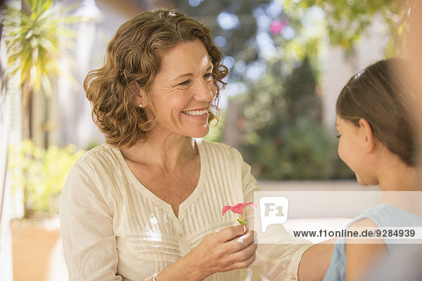 Großmutter bietet Enkelin rosa Blume an