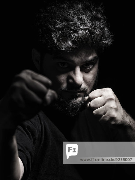 Dramatic portrait of a man in a fighting stance with fists in front of his face
