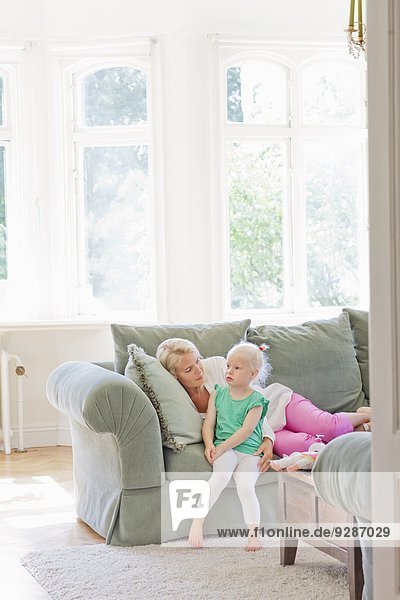 Mother with daughter on sofa